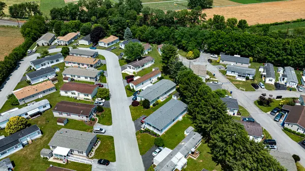 stock image Overhead aerial view of a suburban Mobile, Prefab, Manufactured, neighborhood park, featuring rows of homes, neatly trimmed lawns, and parked cars