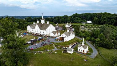 Elizabethtown, Pennsylvania, ABD, 4 Temmuz 2024 - Beyaz Ahırları, küçük kiliseleri, yemek kamyonları ve Yeşillik ve Rolling Hills 'in ortasındaki şenliklerin tadını çıkaran insanlar