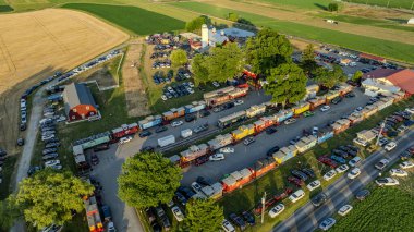 Ronks, Pennsylvania, ABD, 3 Temmuz 2024 - Red Barn, Silo, Crowds, Food Trucks, Park Araba ve Çevre Tarlaları ile Bir Çiftlik Olayının Hava Görüntüsü.