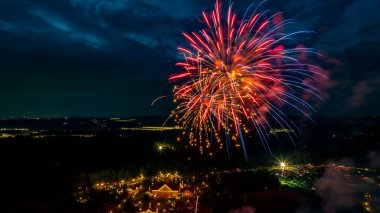 Parlak kırmızı ve altın rengi havai fişekler gece gökyüzünü beyaz ahırlar ve küçük kiliseleriyle aydınlatacak ve karanlık zemine karşı coşkulu ve canlı bir atmosfer yaratacak..