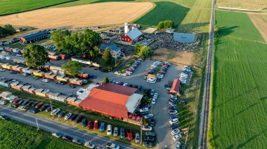 Ronks, Pennsylvania, ABD, 3 Temmuz 2024 - Kızıl Ahır, Silo, Kalabalık, Yiyecek Kamyonları, Geniş Otoparklar ve Demiryolu Rayları Yakınındaki Çevre Alanlarının Hava Görüntüsü.