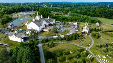 Elizabethtown, Pennsylvania, ABD, 4 Temmuz 2024 - Beyaz Ahırları, küçük kiliseleri, yemek kamyonları ve Yeşillik ve Rolling Hills 'in ortasındaki şenliklerin tadını çıkaran ve canlı bir topluluk atmosferi yaratan insanlar.