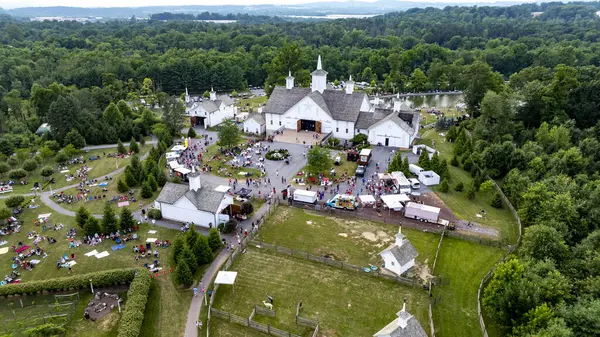 stock image Elizabethtown, Pennsylvania, USA, July 4, 2024 - Charming Rural Fairground With A Scenic Pond, White Barns, Small Churches, And People Enjoying Picnics And Festivities On A Lush Green Lawn, Surrounded