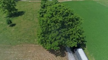 Ronks, Pensilvanya, ABD, 10 Haziran 2022 - Kırmızı çatılı bir trenin her iki tarafında yeşil ve kahverengi alanlar bulunan ve A altında duman ve buhar yayan havadan görünüşü
