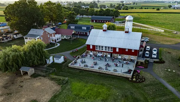 stock image Ronks, Pennsylvania, USA, August 1, 2024 - Guests enjoy dining on the terrace of a rustic farm restaurant surrounded by lush fields at dusk.