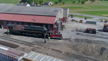 Ronks, Pennsylvania, ABD, 28 Haziran 2022 - Kızıl Endüstri Binası 'nın yanında büyük siyah buharlı bir lokomotif bulunmaktadır.