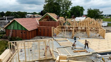 Eldeki Kuş, Pennsylvania, ABD, 6-2024 - Güneşli bir günde ahşap çerçeve ve yapı malzemeleriyle dolu işlek bir inşaat alanının havadan görünüşü,.