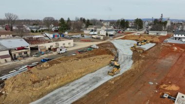 Gordonville, Pennsylvania, 5 Şubat 2025 - Ağır makineler aktif olarak bir banliyö bölgesinde inşaat alanında çalışıyor. İşçiler gelecek binalar için zemin ve altyapıyı hazırlarken,