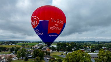 Pensilvanya 'daki Kuş, 13 Eylül 2024 - Canlı bir sıcak hava balonu Pensilvanya' daki Kuş 'un üzerinde yükseliyor, bulutlu bir bölgede nefes kesici manzaralar sunuyor.