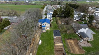 Manzara, konut evleri, bakımlı bahçeler ve ekili tarlaları olan bir banliyö ortamını gösteriyor. İlkbaharda ağaçlar tomurcuklanmaya başladığında yeşil çimenler öne çıkar..