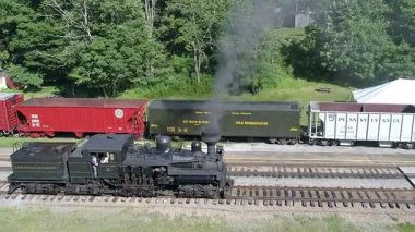 Cass, Batı Virginia, 18 Haziran 2022 eski bir buhar lokomotifi güç ve tarihini gözler önüne sererek Batı Virginia, Cass 'de raylar boyunca seyahat eder. Yeşilli yeşil zemin bu klasik tren yolculuğunun deneyimini arttırır..