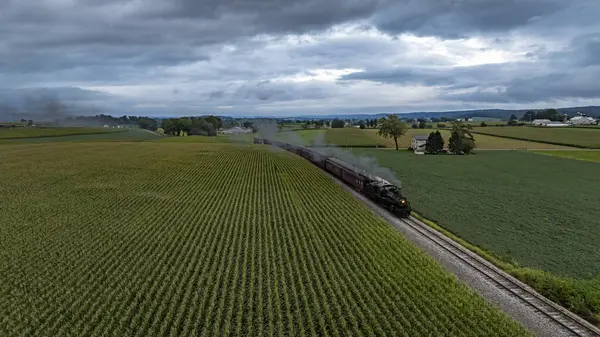 Pensilvanya 'da canlı yeşil alanlarla çevrili dolambaçlı bir pistte klasik bir buhar lokomotifi tıkırdıyor. Tepemizde kara bulutlar belirdi, dramatik bir gökyüzü yarattı..