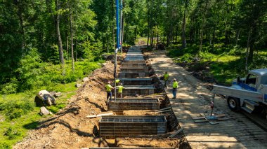 İşçiler ormandaki bir inşaat projesinde çalışıyorlar..