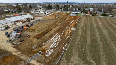 İnşaat Projesi, Baharın Başlarında Yerleşim Alanı ve Çiftlik Alanının yakınındaki Peyzaj Dönüşümü Projesi. Yüksek kaliteli fotoğraf makineleri, evlerin ve açık alanların yakınlarındaki bir inşaat sahasında çalışıyor. Şey...