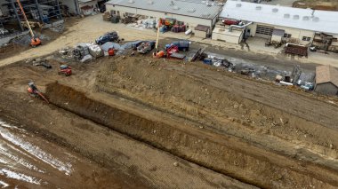 Kırsal bir alanda, Ağır Makineler ve Malzemeler ile Büyük bir Alanda İnşaat Etkinliği. Yüksek kalite fotograf sitesinde yer değiştiren işlerde çalışan ağır makineler görülüyor. Çeşitli