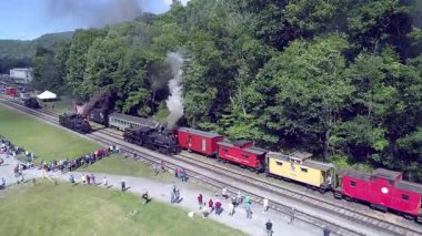 Cass, Batı Virginia, 18 Haziran 2022 - Cass Sahne Demiryolu 'ndaki bir buhar geçidinde gölgeli lokomotifler sergilenen hava görüntüleri yemyeşil ve izleyiciler göz kamaştırıcı görsel ışıklandırma