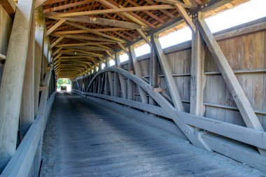 Tarihi ahşap köprü sergilerinin içi ahşap kirişler ve kirişlerle kaplıdır. Güneş ışığı, bu mimari mucizenin kırsal cazibesini artırmak için sıcak bir parıltı verir..