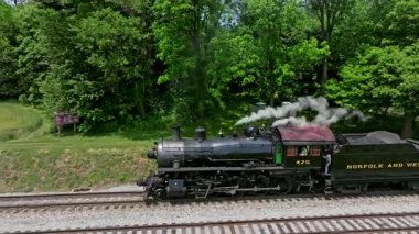 Ronks, Pennsylvania, 5 Mayıs 2023 - Tren rayları boyunca uzanan 475 buharlı lokomotif canlı yeşil ağaçlarla çevrili, tarihi önemini ve çekiciliğini sergiliyor. Yolculuk,