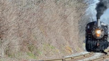 Paradise, Pennsylvania, February 24, 2024 - A Steam Passenger Train Approaches Head on, Blowing Smoke and Steam on a Windy Day