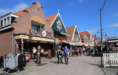 Volendam, The Netherlands - September 12, 2019: Tourists walk along historical houses and souvenir shops in Volendam, The Netherlands on September 12, 2019