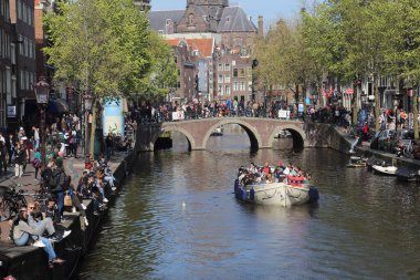 Amsterdam, Hollanda - 16 Nisan 2022: Amsterdam, Hollanda 'da 16 Nisan 2022' de turistlerle birlikte Amsterdam 'da kanal