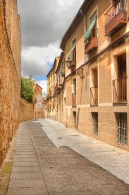İspanya, Segovia 'da tarihi evleri olan antik dar kaldırım taşı caddesi.