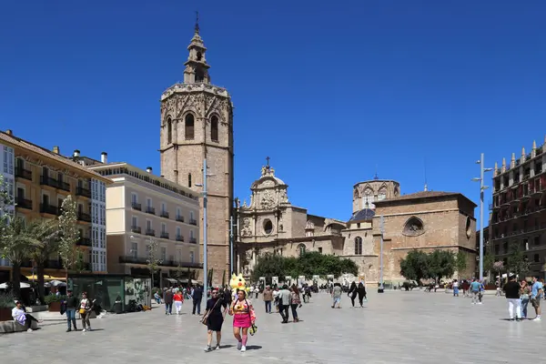 Valencia, İspanya - 17 Nisan 2023 Placa de la Reina ve Miguelete Kulesi, Valencia Katedrali 'nin kilise kulesi ve yürüyen insanlar 17 Nisan 2023.