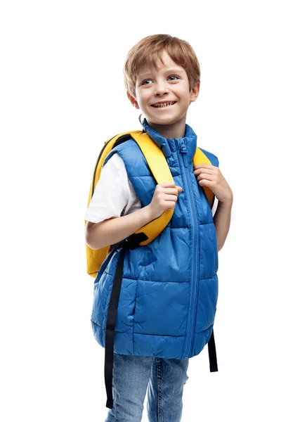 陽気な少年は白い背景を離れて見て黄色のバックパックを着ている 学校に戻る 笑顔の子供 ロイヤリティフリーのストック写真