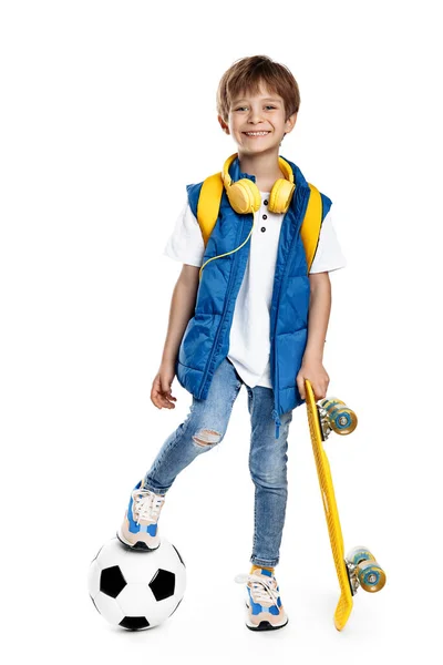可爱的金发碧眼的男孩 黄色的滑板 脚踏在白色背景的足球上 回学校去 — 图库照片