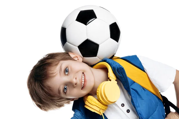 滑稽的小男孩头顶着足球在白色的背景上 回学校去 — 图库照片