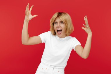 Kırmızı arka planda beyaz giysili kızgın sarışın kadın çığlık atıyor.