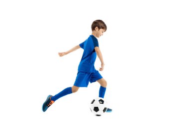 Kendine güvenen mavi spor kıyafetli genç beyaz arka planda klasik futbol topuyla oynuyor..