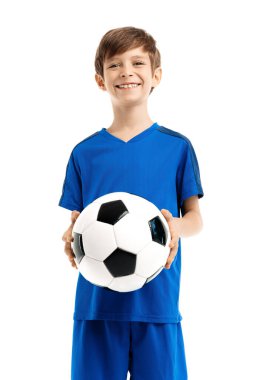 Mavi spor kıyafetli komik çocuk beyaz arka planda klasik futbol topuyla poz veriyor..