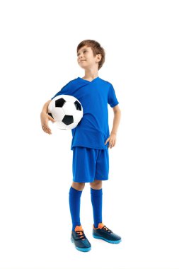 Mavi spor kıyafetli, beyaz arka planda klasik futbol topuyla poz veren kendinden emin genç bir çocuk. Uzaklara bakıyorum..