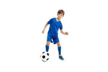 Kendine güvenen mavi spor kıyafetli genç beyaz arka planda klasik futbol topuyla oynuyor..