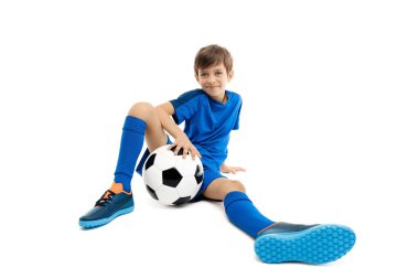Mavi spor kıyafetli genç beyaz arka planda klasik futbol topuyla poz veriyor. Geniş açı resmi.