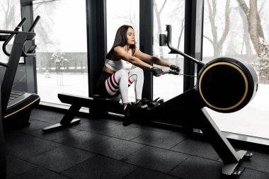 Spor salonunda kürek çeken aktif bir kadın var. Fonksiyonel eğitim.