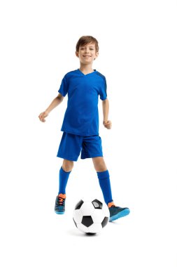 Mavi spor kıyafetli genç klasik futbol topuyla oynuyor..