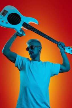 Beyaz bas gitar tutan ve neon ışıklarda bağıran modaya uygun hippi. Rock müzik konsepti