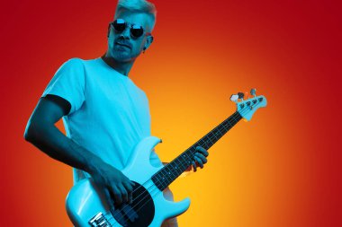 Modayı takip eden hippi, neon ışıklarda beyaz bas gitar çalıyor. Rock müzik konsepti