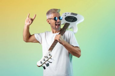 Kendine güvenen hippi, neon ışıklarda beyaz bas gitar çalar. Rock müzik konsepti. Kaya hareketi.