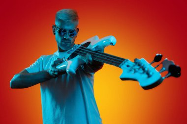 Sarışın hippi, neon ışıklarda beyaz bas gitar tutuyor. Rock müzik konsepti