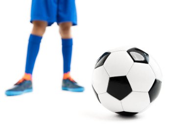 Beyaz arka planda klasik futbol topuyla oynayan genç çocuğun yakın plan fotoğrafı..