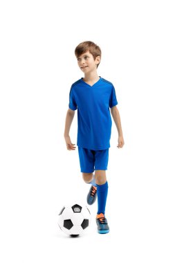 Mavi spor kıyafetli çalışkan genç beyaz arka planda klasik futbol topuyla oynuyor..