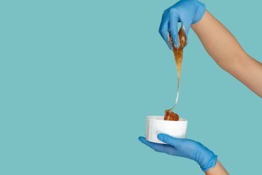 Mavi arka planda poz veren kozmetolog ya da doktor.