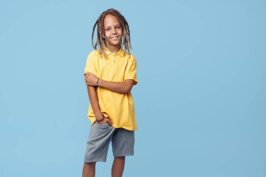 Mavi arka planda Afrika korkusu olan ürkek küçük bir çocuğun portresi.