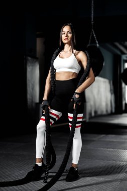 Mükemmel vücutlu çekici genç bir kadın spor salonunda iple egzersiz yaptıktan sonra poz veriyor..