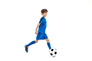 Mavi spor kıyafetli genç, beyaz arka planda klasik futbol topuyla oynuyor..