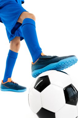 Yakın plan görüntü, genç futbolcu, mavi spor kıyafetli klasik futbol topunun bacağını tutuyor..