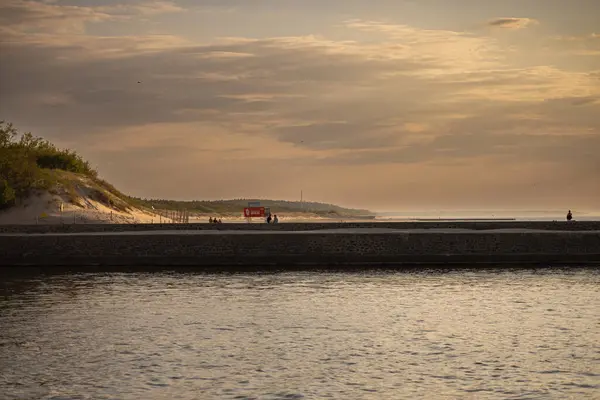 Gün batımında Ustka 'daki rıhtım ve sahil manzaralı.